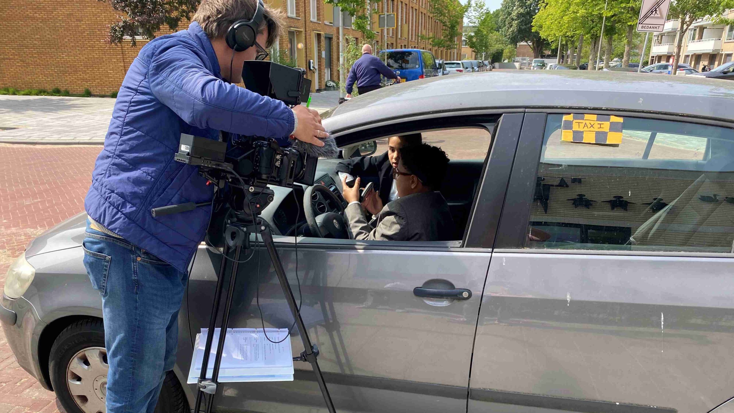Een cameraman filmt leerlingen in een taxi voor de eindfilm van groep 8