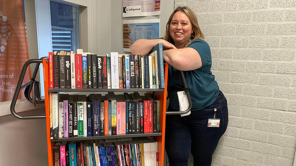 Taalcoördinator van het mbo bij een boekenkar