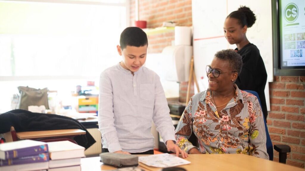 Leerling laat trots zijn werk zien aan leerkracht