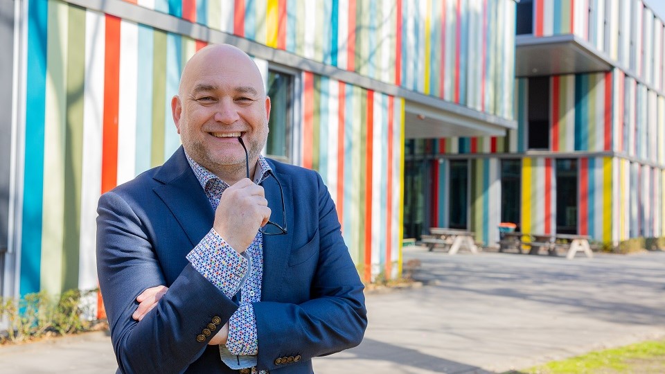 Leraar Remko Droop voor een schoolgebouw