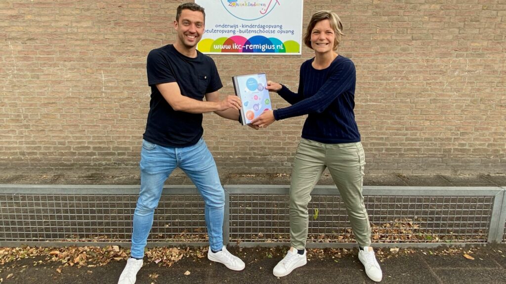 Mark en Marenka doen een warme overdracht op het schoolplein.