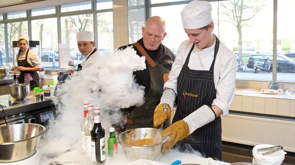 Topchef en practor Pierre Wind staat met studenten in een praktijk keuken.