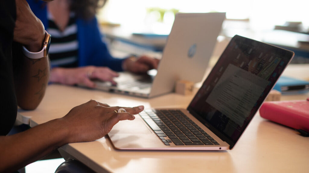 hand bij een laptop