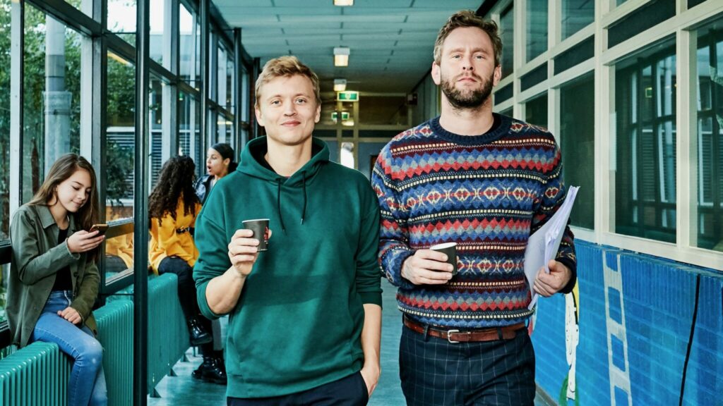 Tim den Besten en Nicolaas Veul lopen door de gang van een middelbare school.