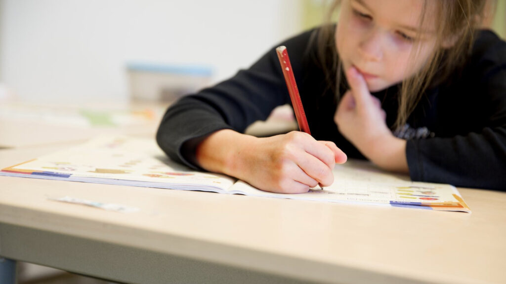 Leerling schrijft in een schrift