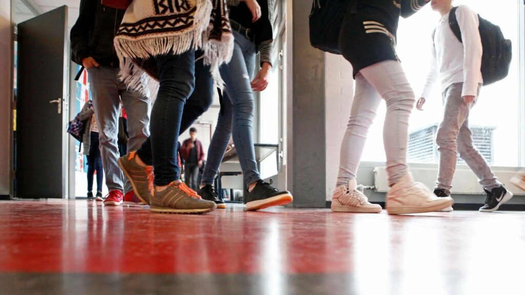 Middelbare scholieren lopen door een schoolgang