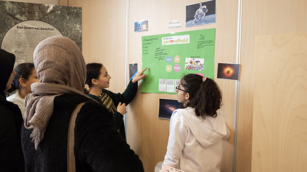 meisjes kijken naar een poster op de muur