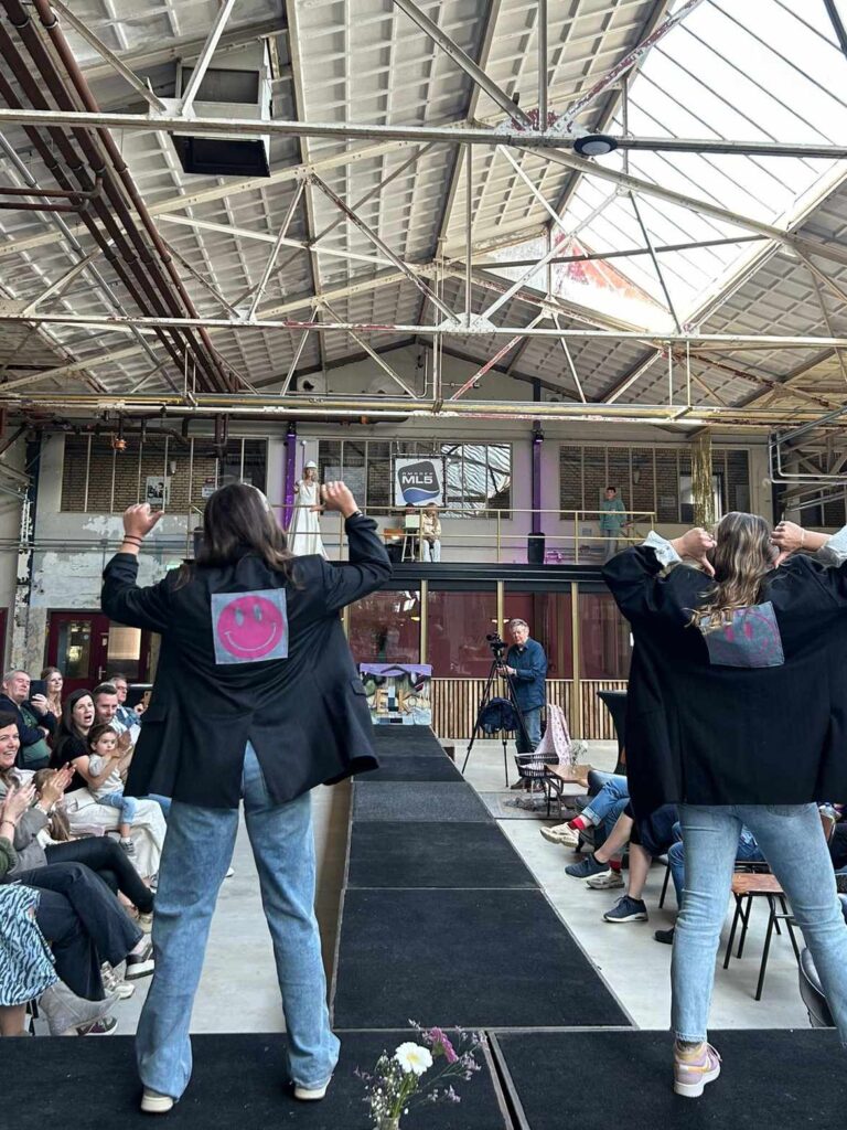 modeshow van leerlingen in een fabriekshal